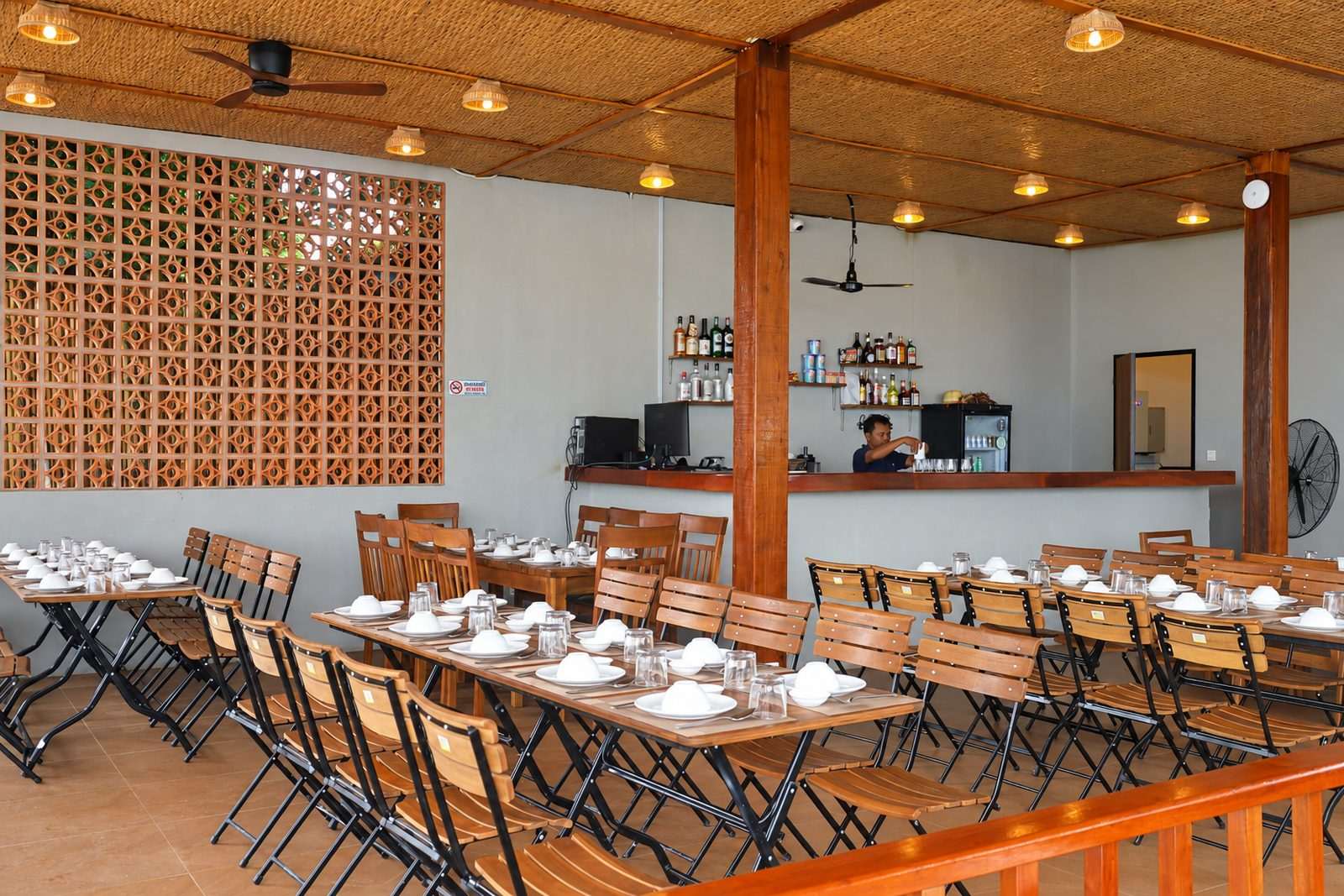 The bar with staff on duty and tables laid under the timber ceiling