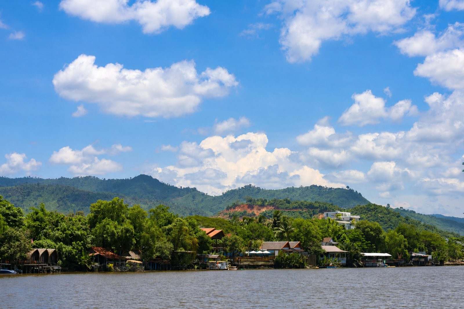The Kampot river with green hills rising behind it