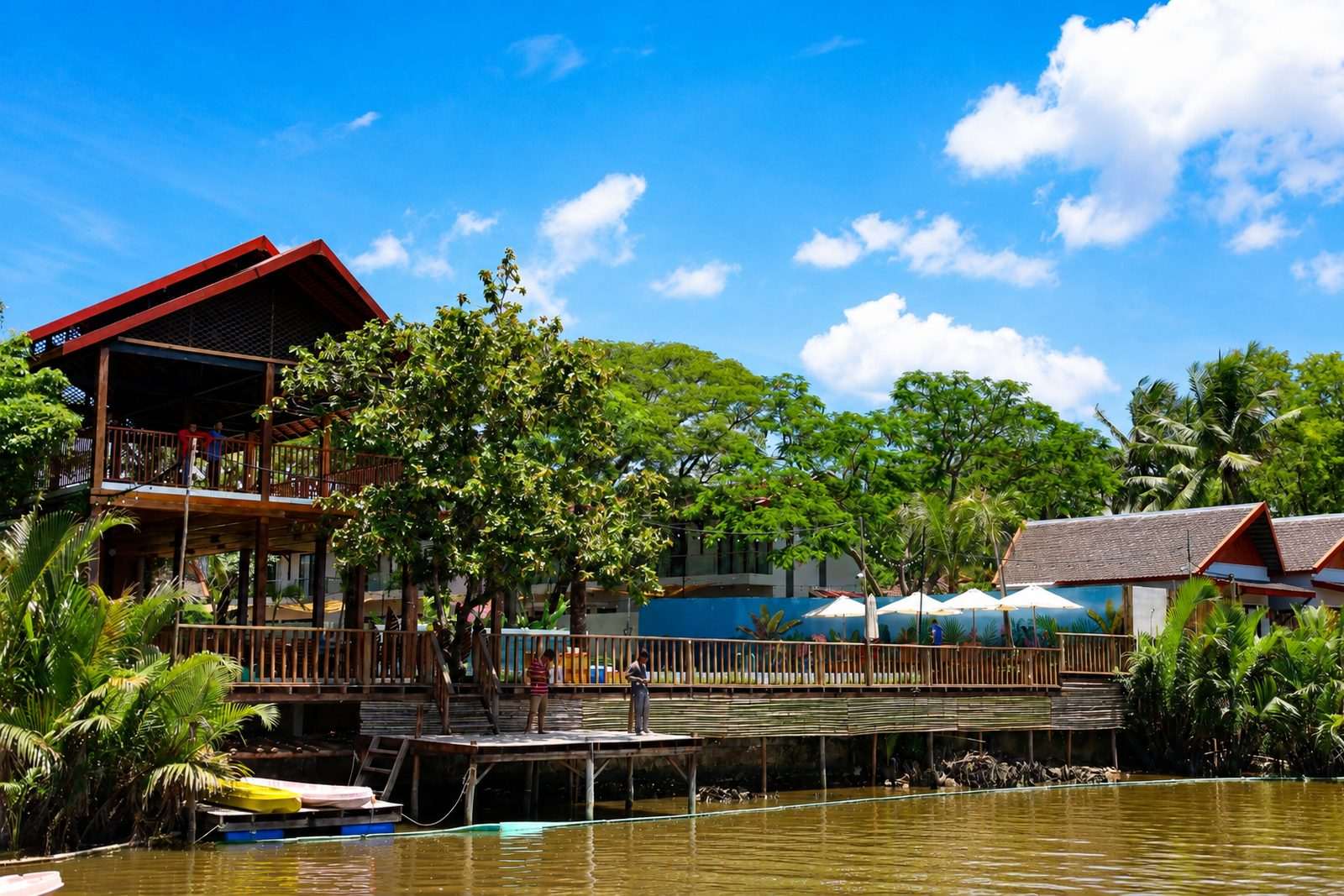 The two-storey riverside building and its deck seen from the water